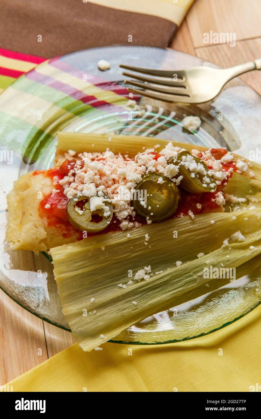 Mexican steamed chili and cheese masa tamales wrapped in corn husk
