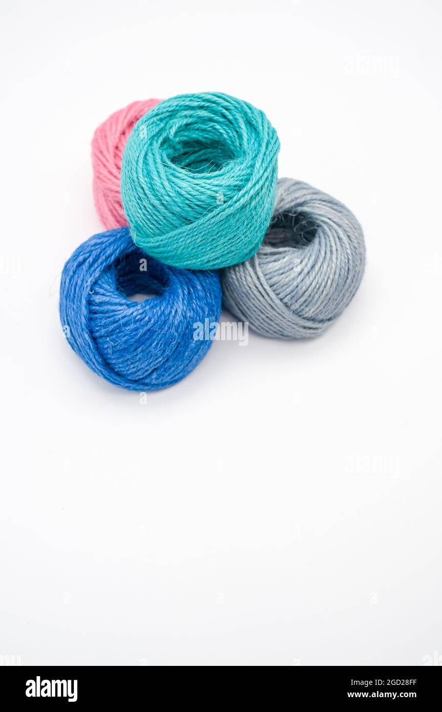 Vertical shot of colored cotton threads on a white background Stock Photo