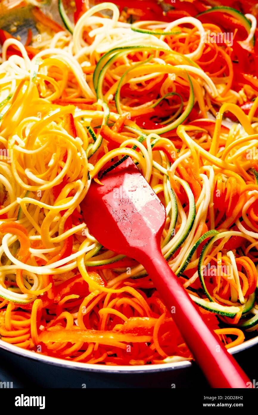 https://c8.alamy.com/comp/2GD28H2/cooking-and-stirring-zucchini-noodles-in-pan-on-stove-for-vegetarian-pad-thai-2GD28H2.jpg