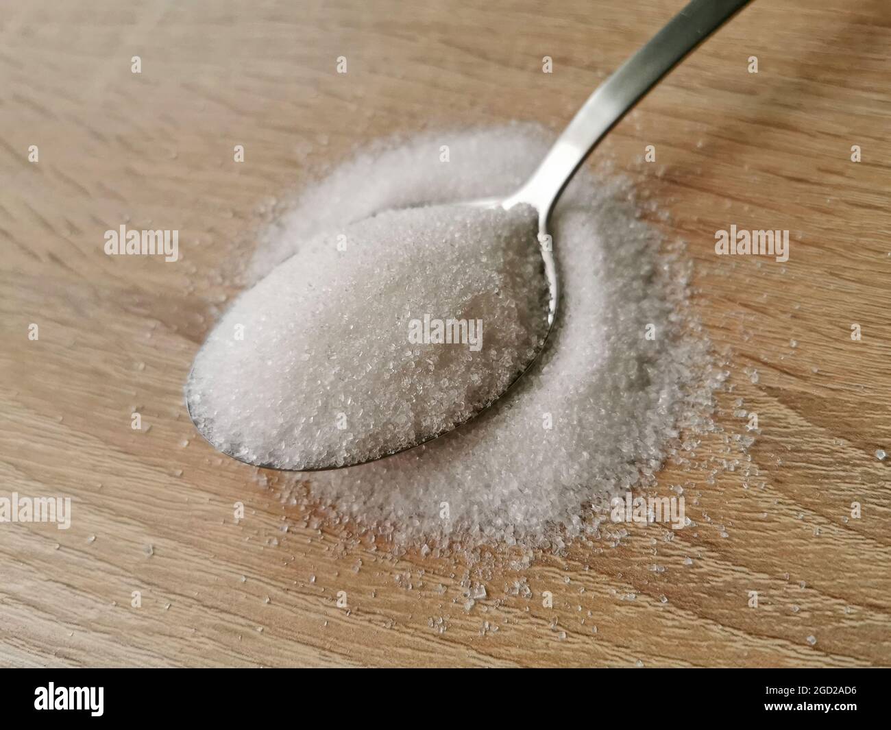 Spoon with white sugar on wooden background Stock Photo