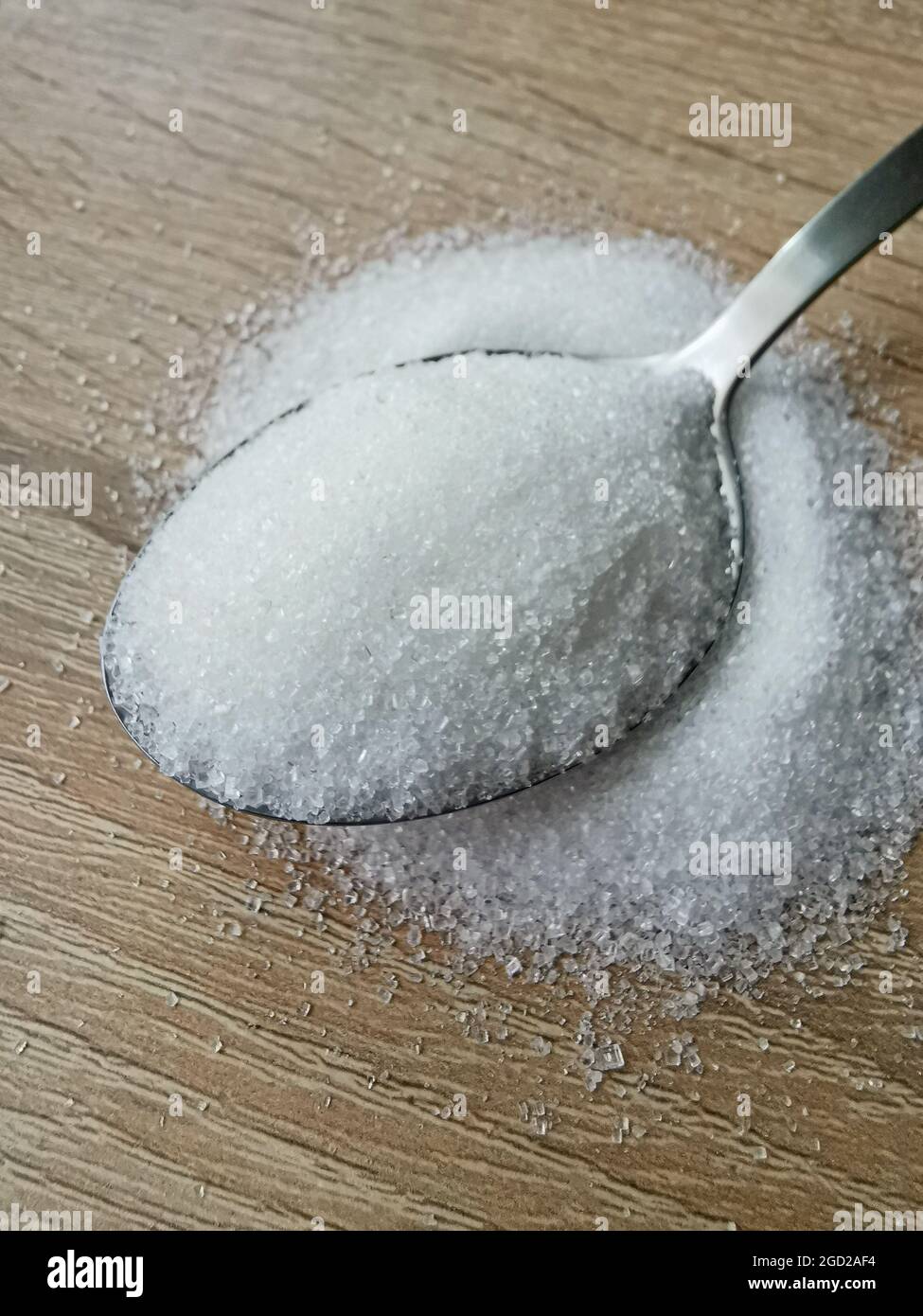 Spoon with white sugar on wooden background Stock Photo