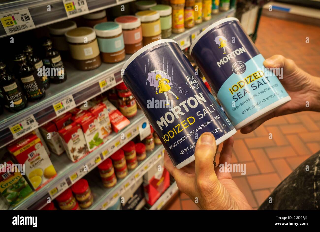 A shopper chooses containers of Morton brand iodized salt and sea salt in a supermarket in New York on Monday, August 2, 2021. Morton Salt announced that it was terminating 120 employees in its Chicago headquarters. (© Richard B. Levine) Stock Photo