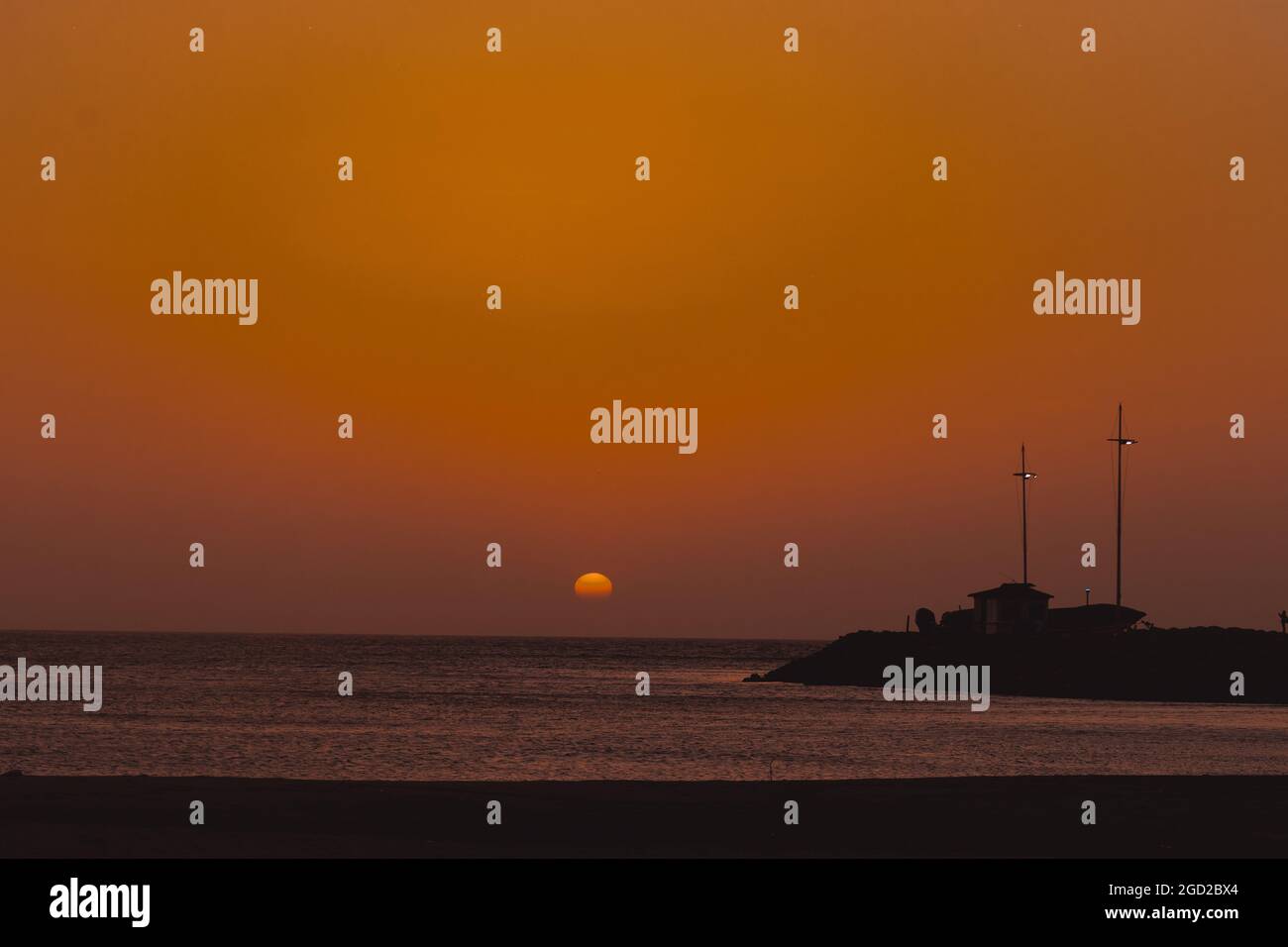 Beautiful orange sunset over a sea near an island Stock Photo - Alamy