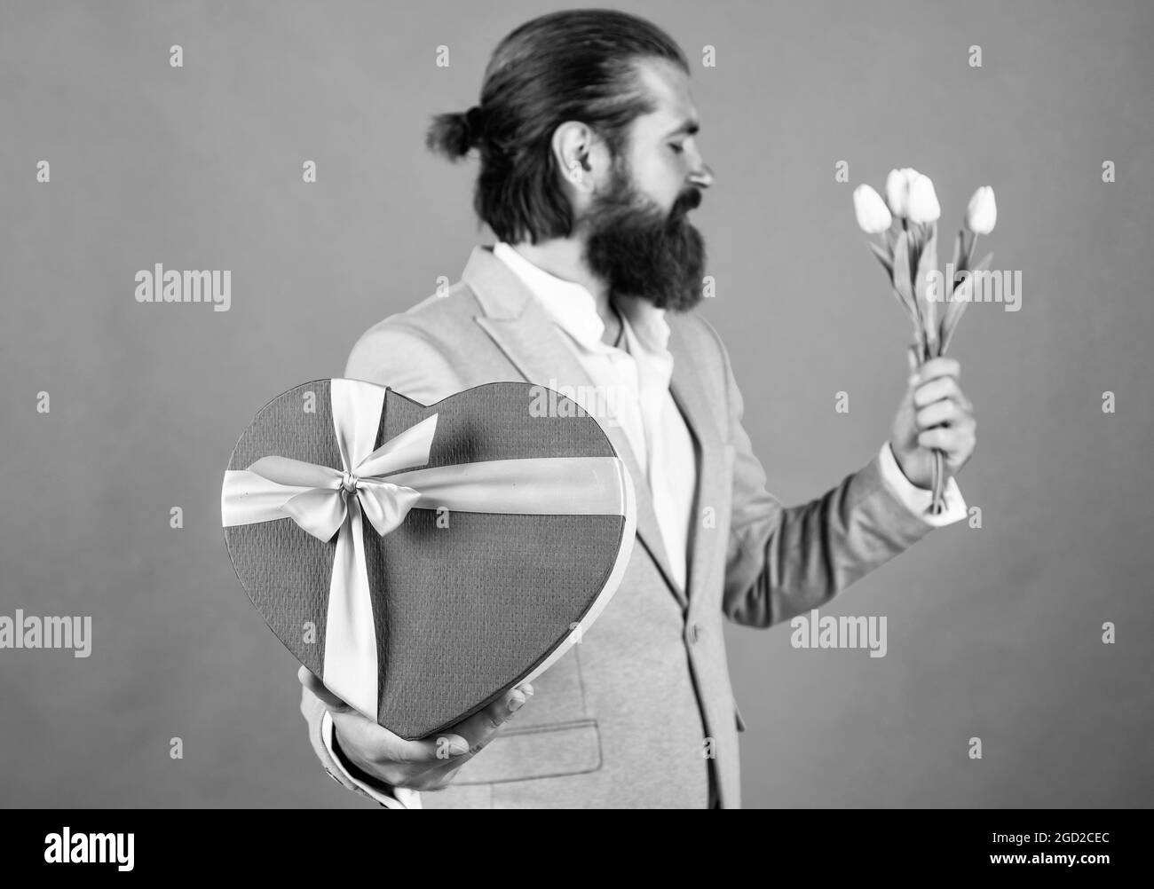 Happy man holds a large bouquet of red roses, propose to boyfriend on date....