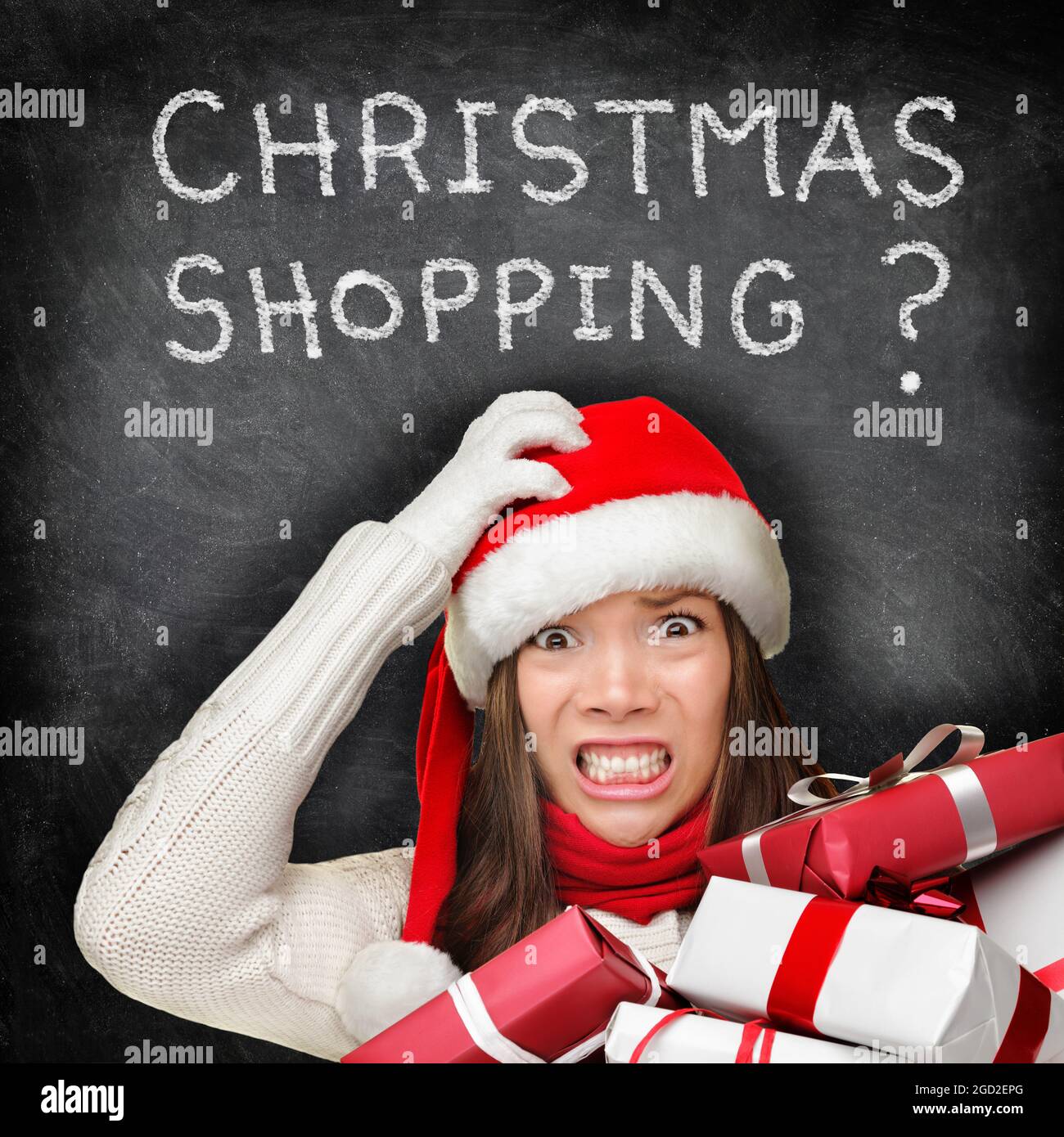 Christmas stress holiday shopping woman in santa hat stressed funny  expression with CHRISTMAS SHOPPING written on black chalkboard. Anxious  Asian lady Stock Photo - Alamy