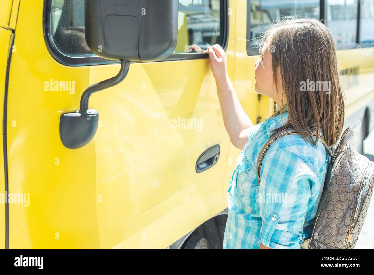 Photo of a blonde girl getting on the school bus Stock Photo