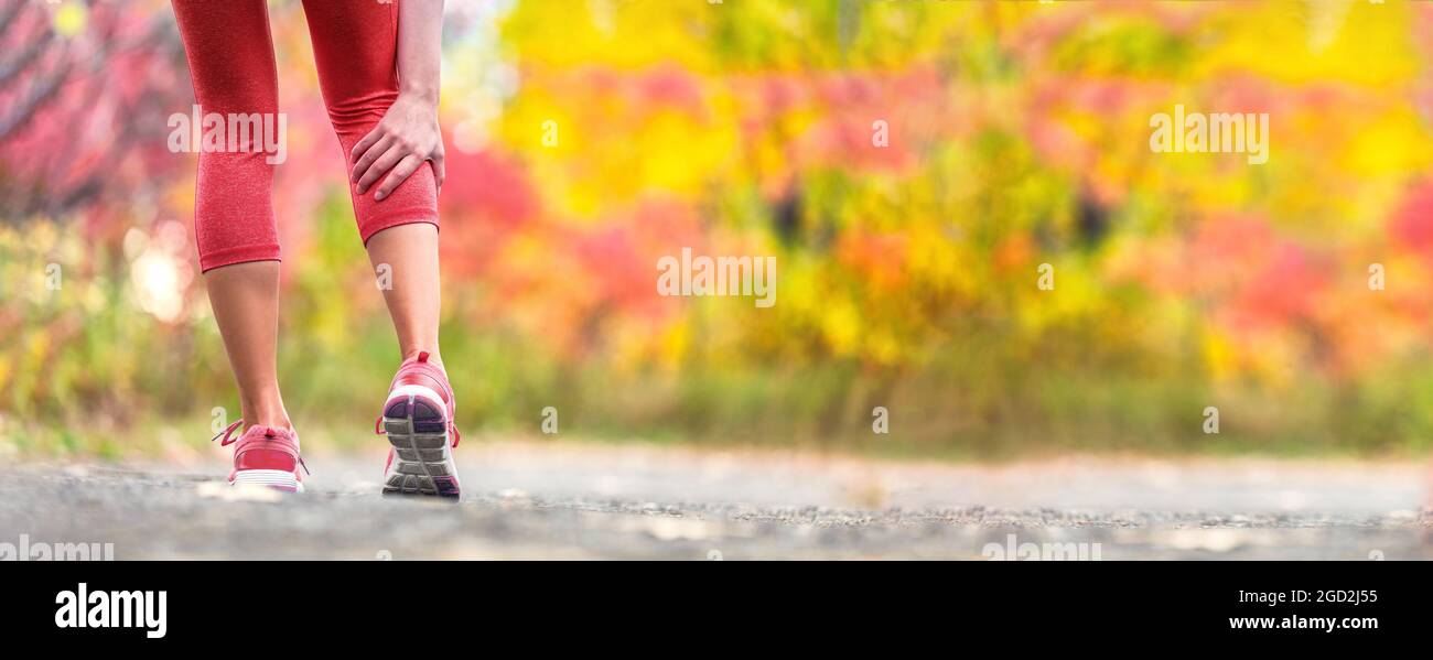 Sport injury runner woman in pain holding back leg calf muscle hurting from cramp during trail run outdoor exercise. Running muscles accident. Stock Photo