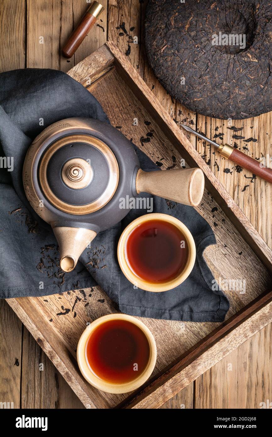 Medicinal Pu-erh tea in ceramic cups on wooden background Stock Photo