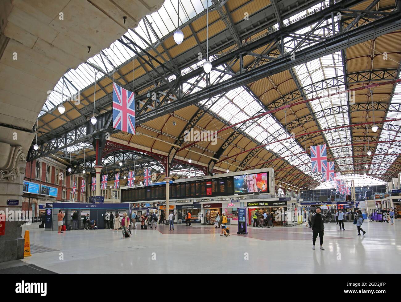 The main concourse at London's Victoria Station. Shows departure board, ticket barriers and the Victorian vaulted roof. Stock Photo