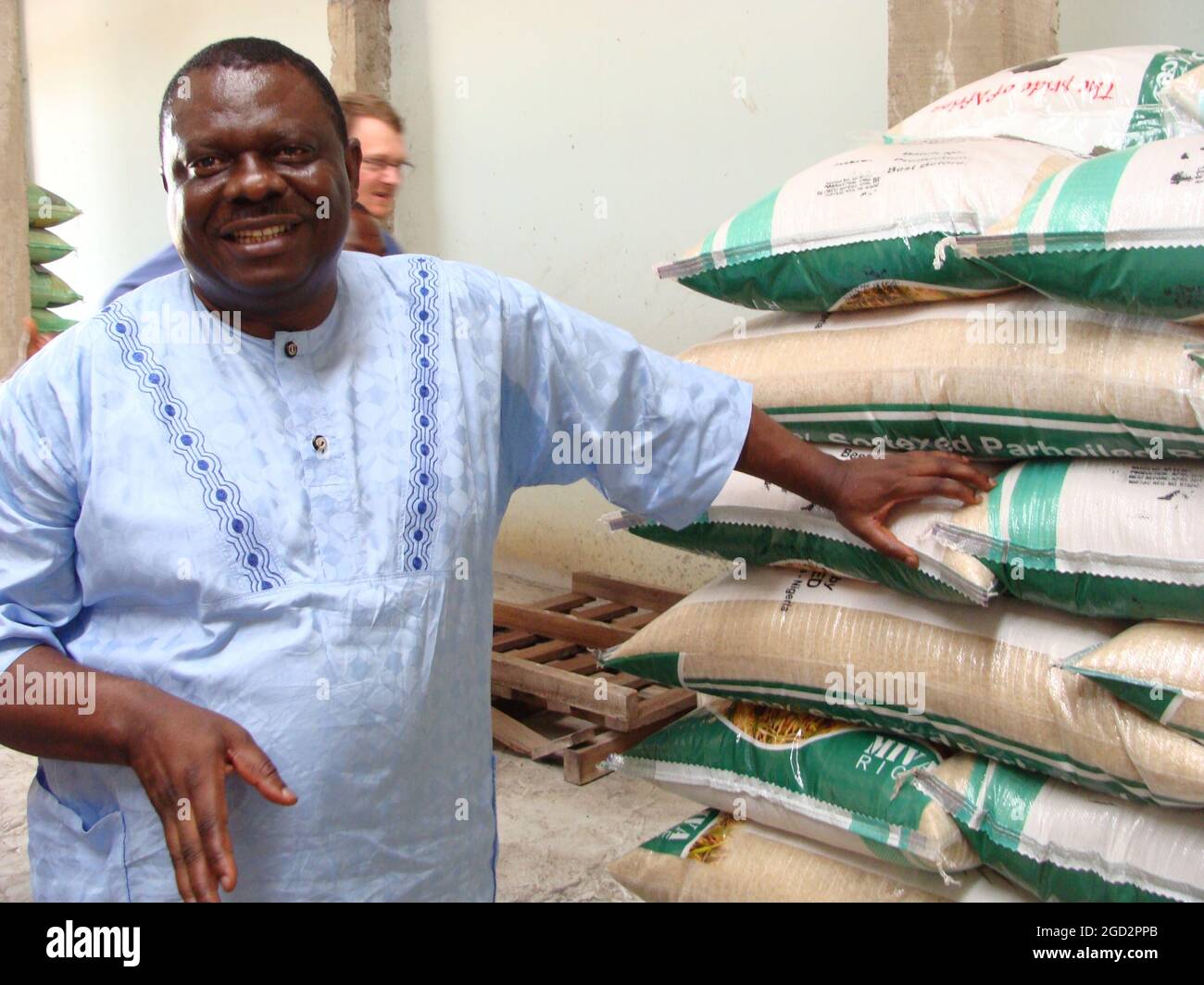 Nigerian farmer and bags of processed rice ca. 17 May 2014 Stock Photo