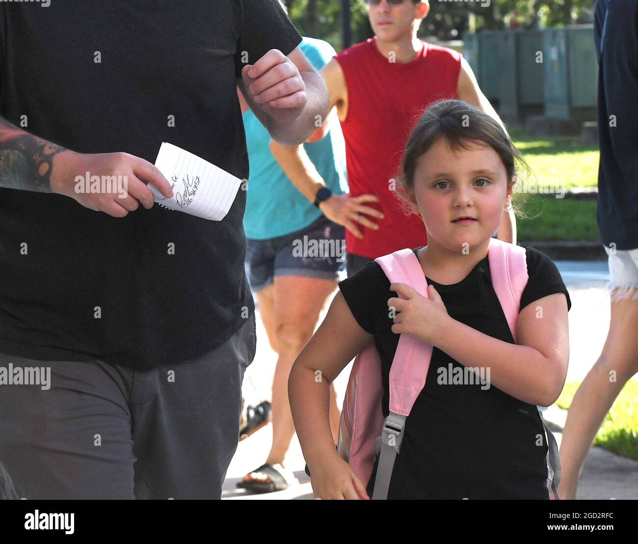 Orlando, United States. 10th Aug, 2021. A young girl arrives on the first day of classes for the 2021-22 school year at Baldwin Park Elementary School. Due to the current surge in COVID-19 cases in Florida, Orange County public schools have implemented a face mask mandate for students for 30 days unless a parent chooses to opt out of the requirement. Credit: SOPA Images Limited/Alamy Live News Stock Photo