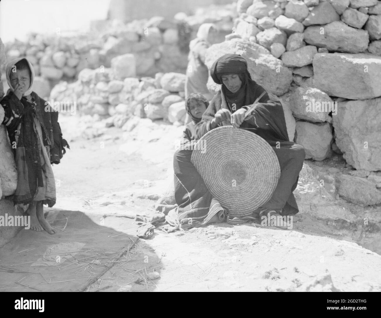 Woman weaving a straw mat. Semi Bedouin type in M'Keis, ancient Gadara
