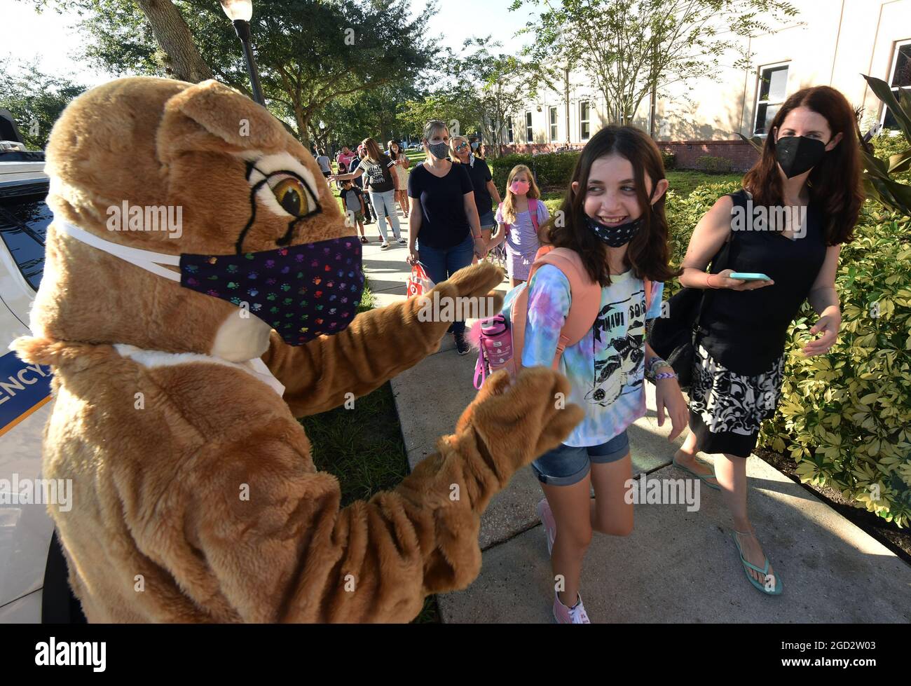 Orlando, United States. 10th Aug, 2021. A masked school mascot in a bobcat costume greets students as they arrive on the first day of classes for the 2021-22 school year at Baldwin Park Elementary School. Due to the current surge in COVID-19 cases in Florida, Orange County public schools have implemented a face mask mandate for students for 30 days unless a parent chooses to opt out of the requirement. (Photo by Paul Hennessy/SOPA Images/Sipa USA) Credit: Sipa USA/Alamy Live News Stock Photo
