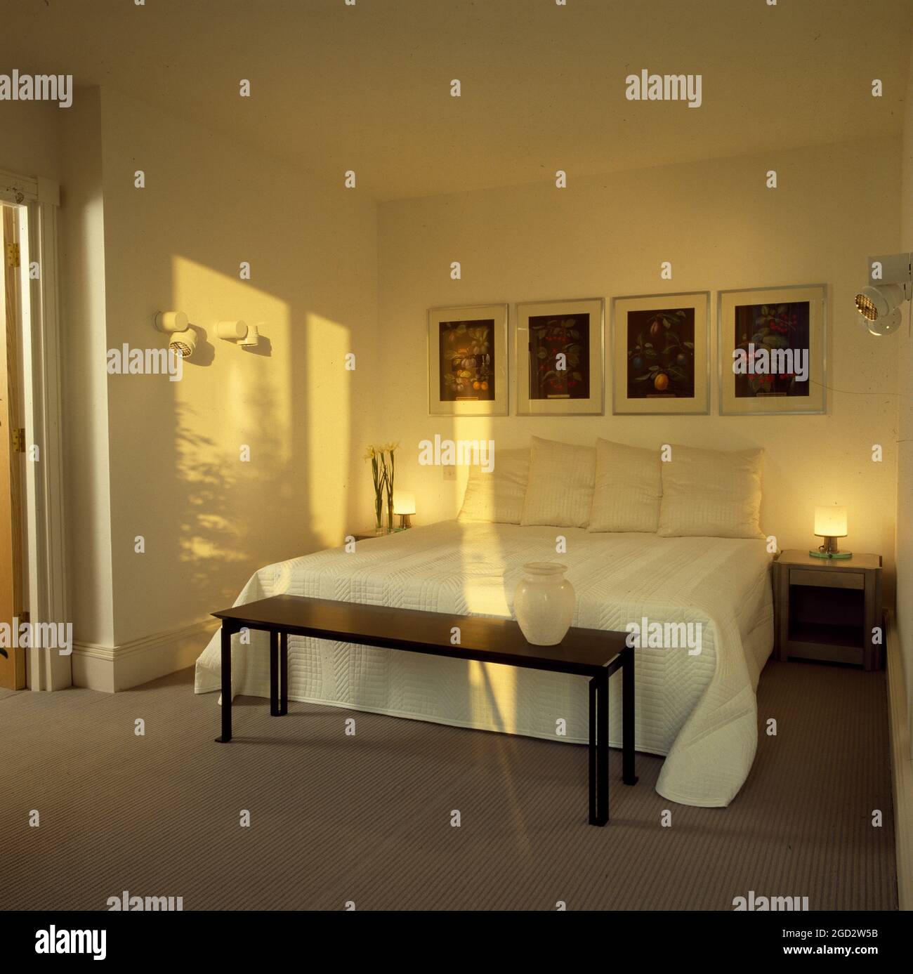 Cream double bedroom with bedside lights Stock Photo