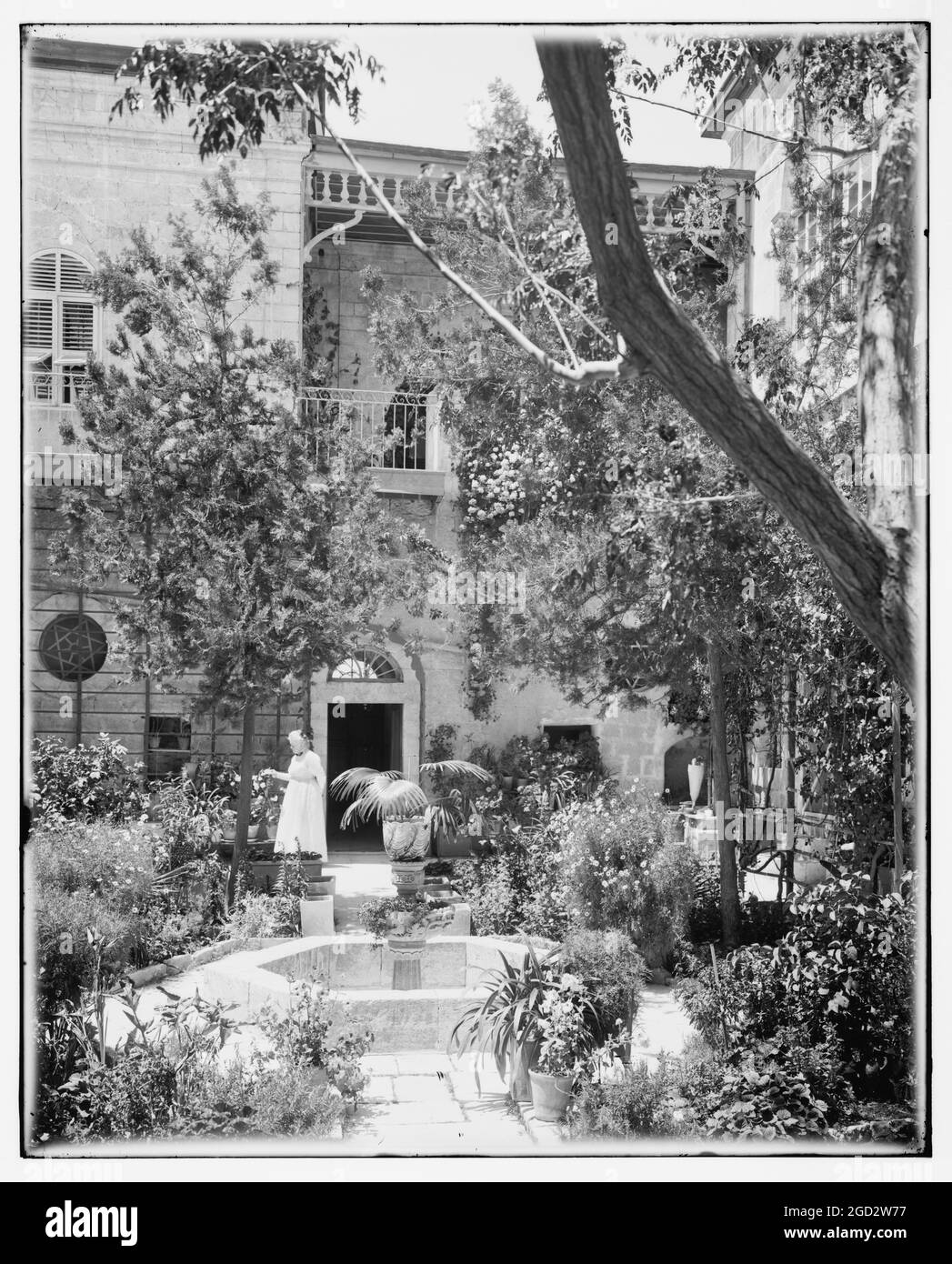 A woman tending the garden in the American Colony courtyard ca. between 1898 and 1923 Stock Photo