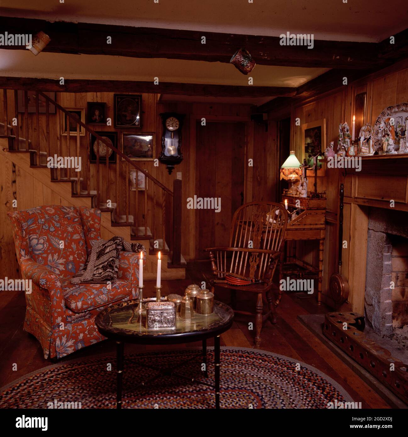 Traditional livingroom with wooden panelling and beams and chintz covered chair. Stock Photo