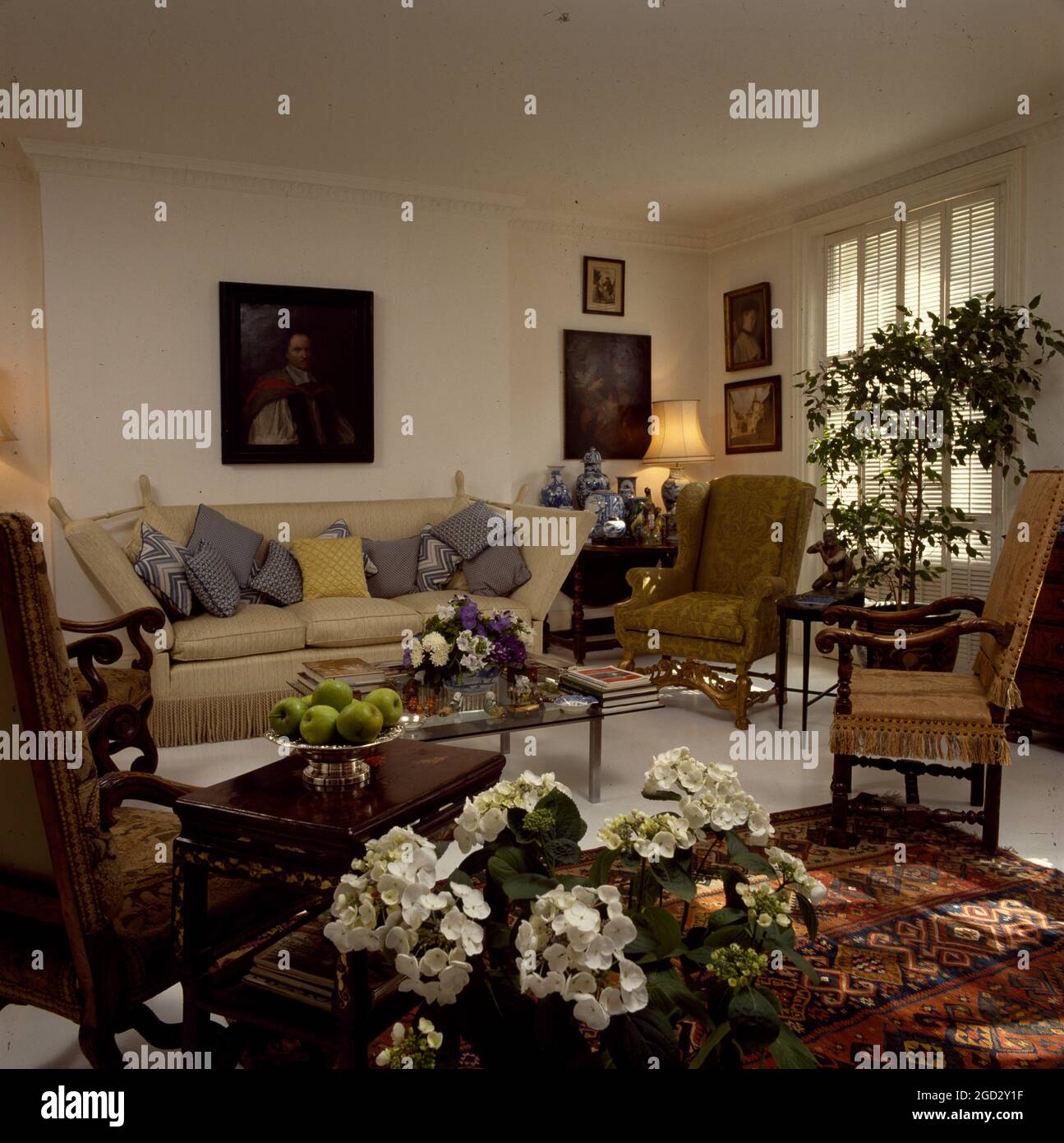 Designer livingroom in NYC with flowering plants and antique furniture. Stock Photo