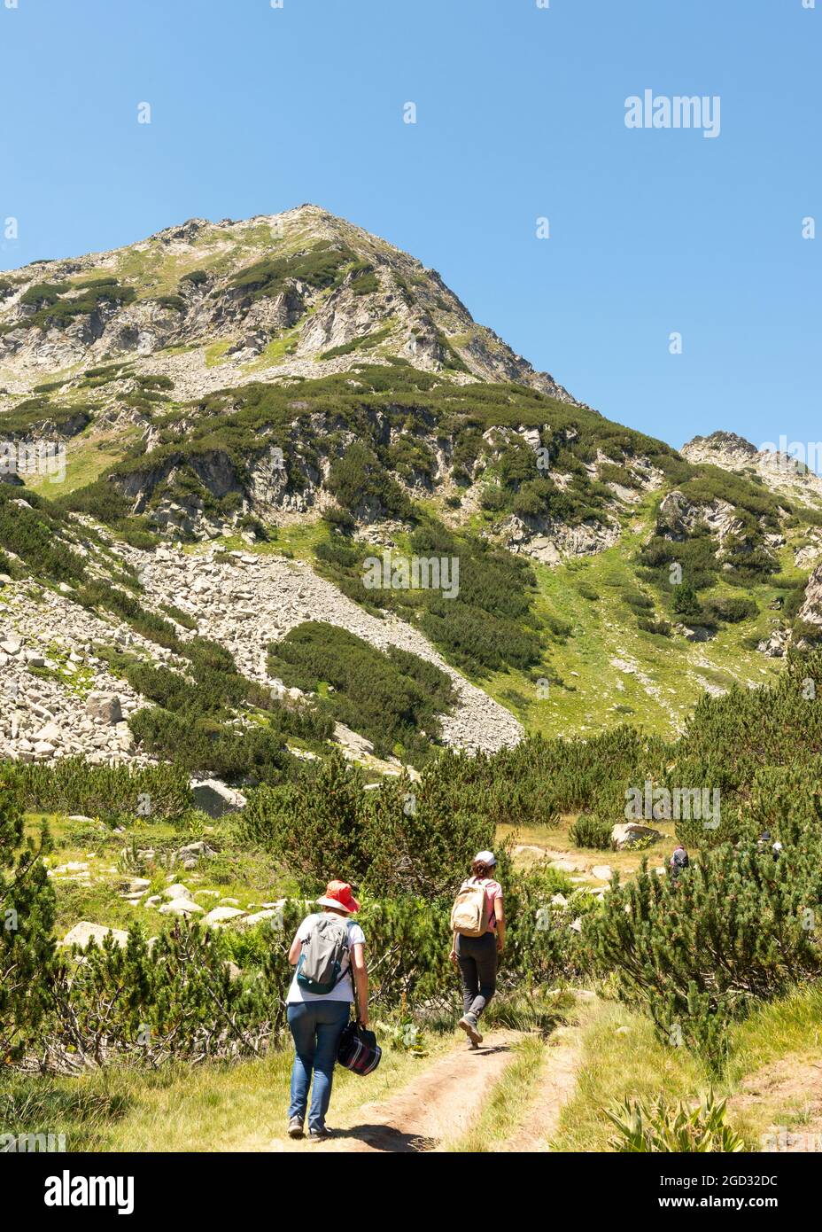 Bulgaria hiking. Hikers on hiking trail approaching Muratov Peak in Pirin National Park and Reserve, Pirin Mountain, Bulgaria, Balkans, Europe Stock Photo