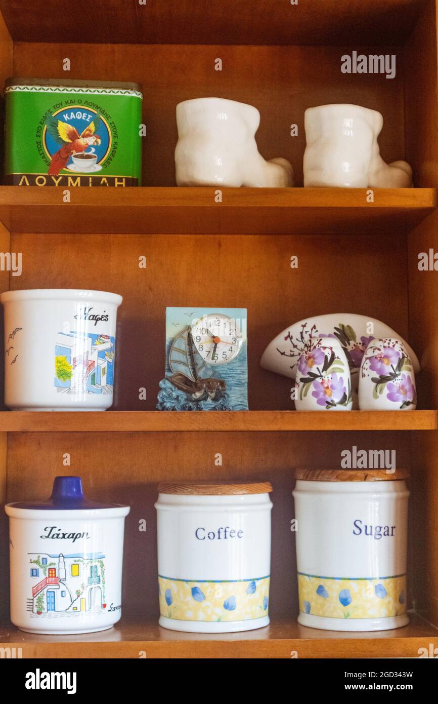 Traditional ceramic set storage for sugar, coffee and spices. Cookware details on kitchen shelf in Greek house, in Greece. Vertical Stock Photo