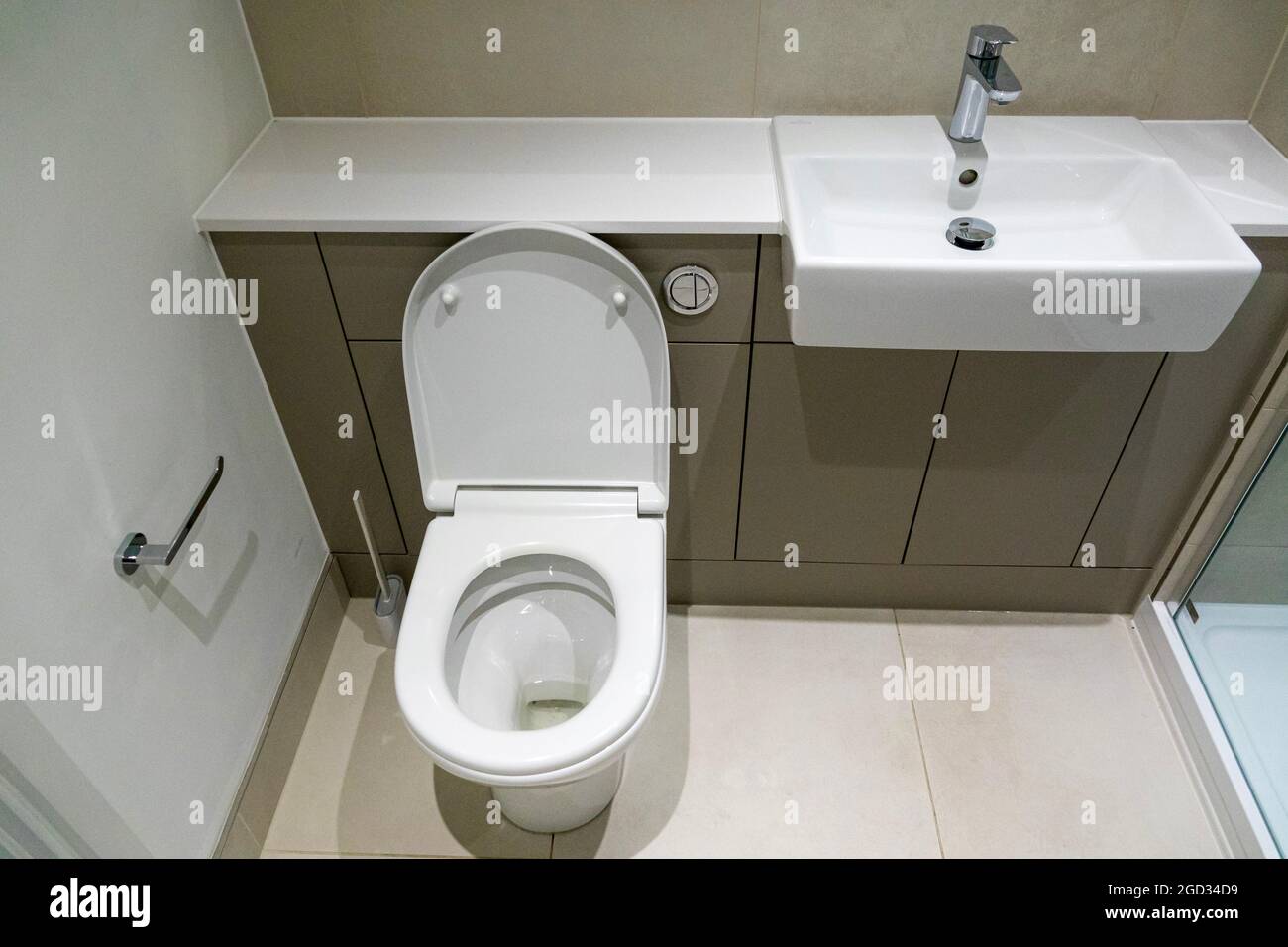 Toilet and sink in a modern new apartment. Grey and white