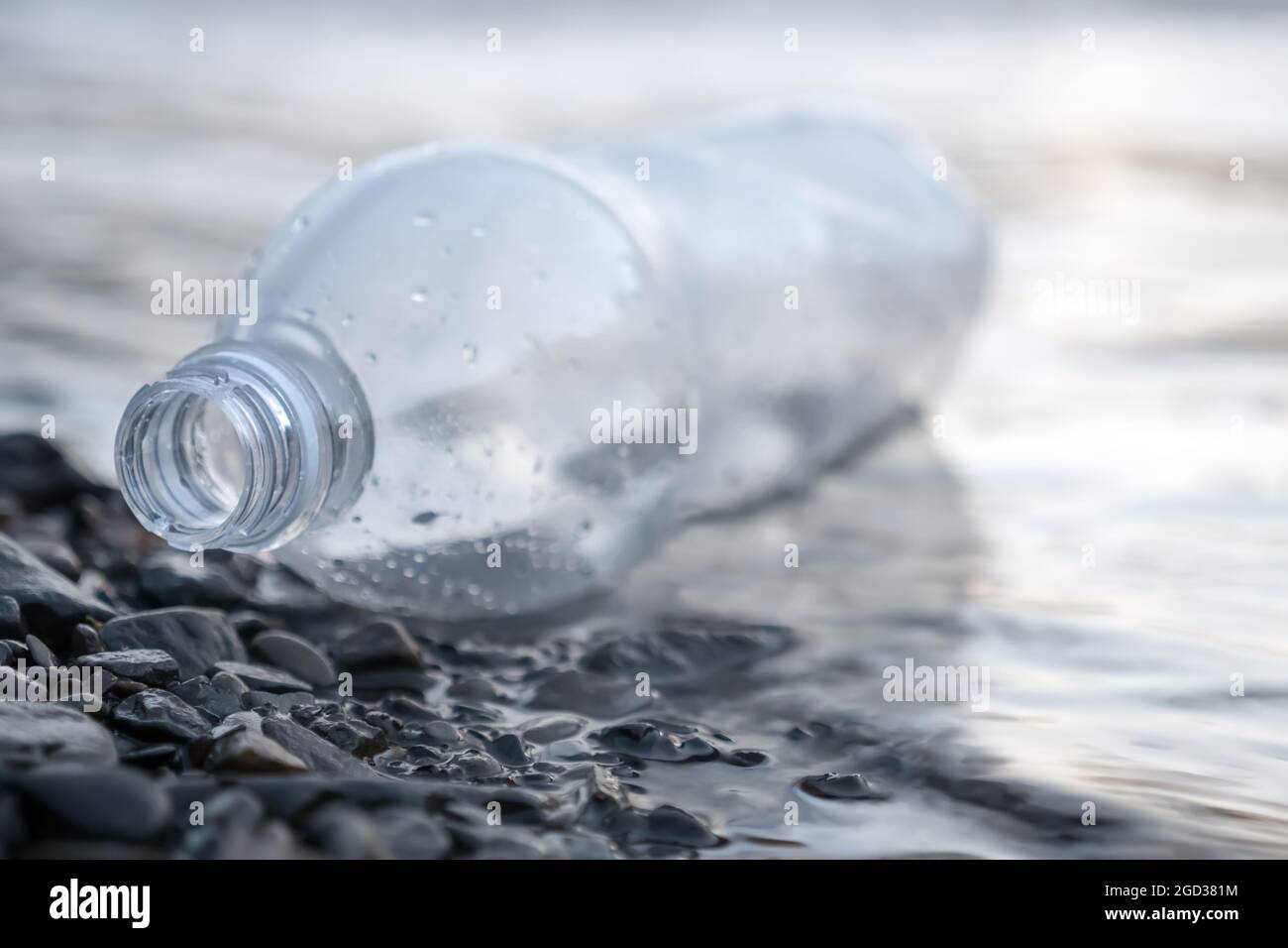 Discarded bottle plastic garbage sea waste. Ecology pollution of nature. Environmental problems. Sea pollution garbage water trash on beach. Empty Stock Photo