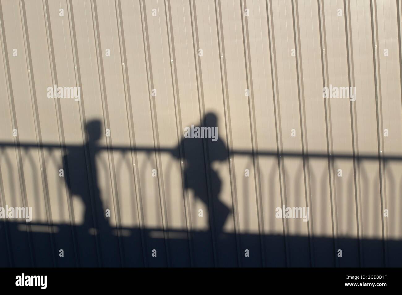 Shadows of people standing on the bridge. The silhouette of guys ...