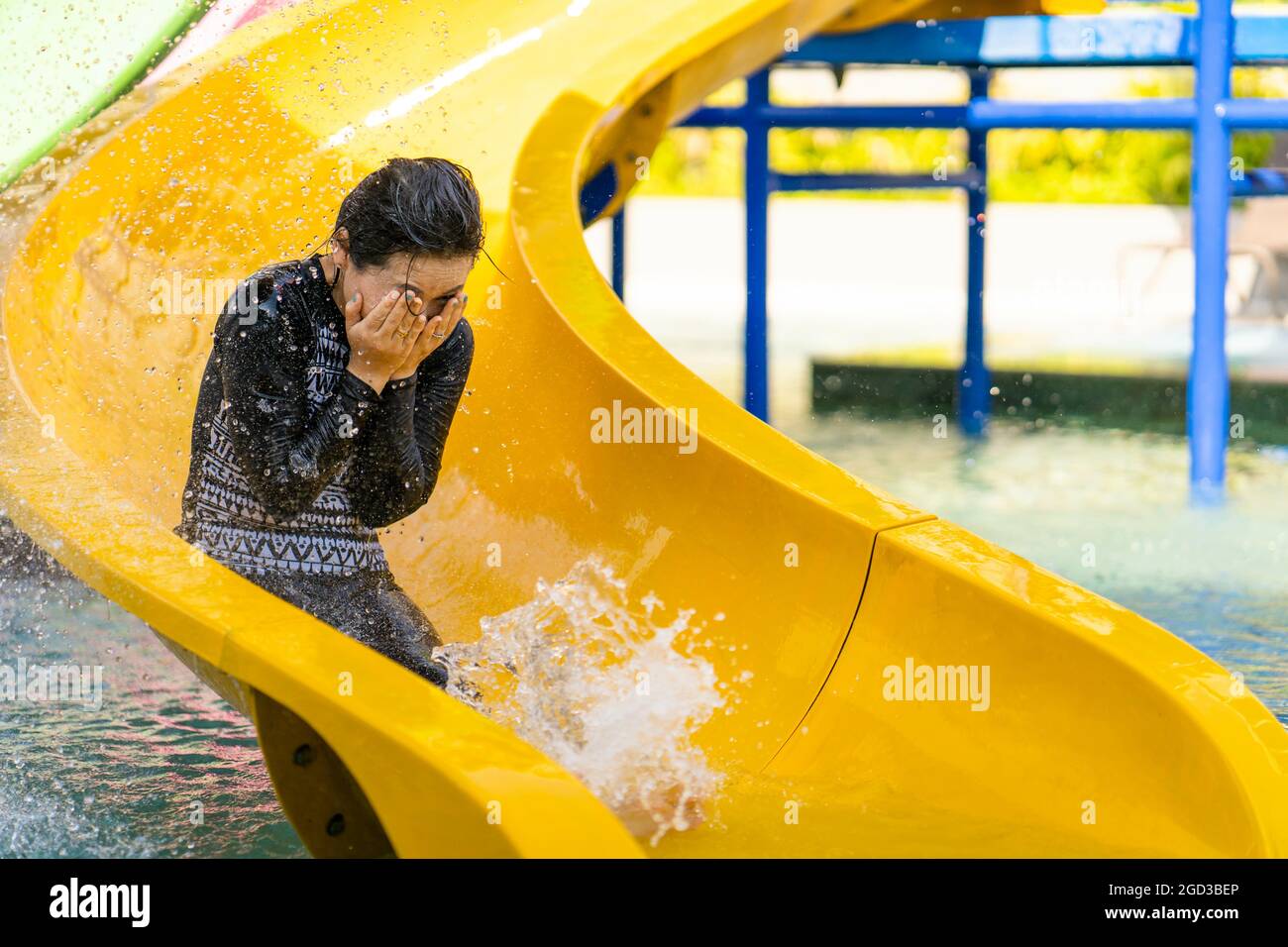 Young Asian female going down a water slide Stock Photo - Alamy