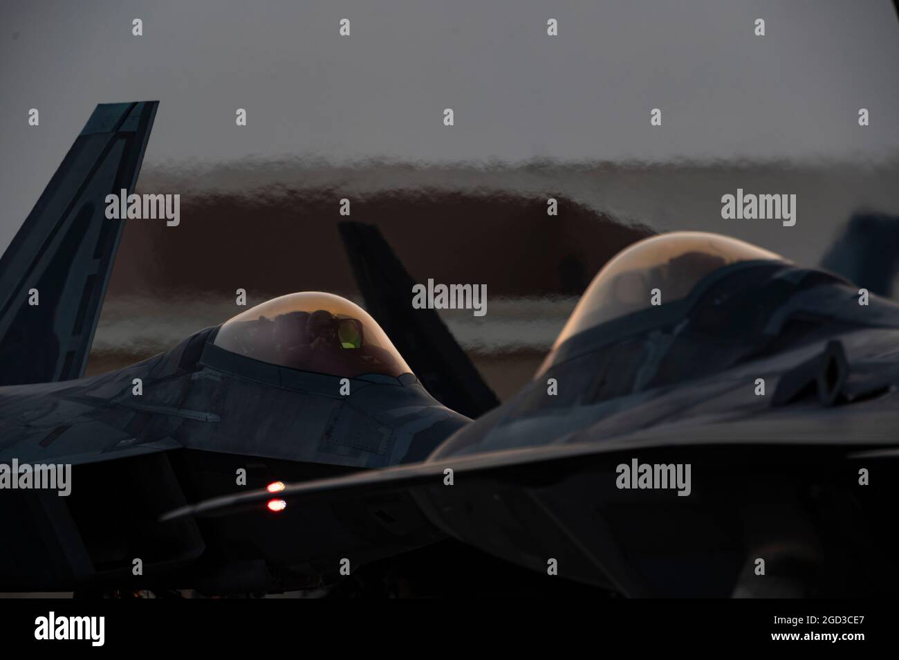 Two F-22 Raptors assigned to the 1st Fighter Wing, Langley Air Force Base, Virginia, are started up for a night training mission during Red Flag-Nellis 21-3 at Nellis Air Force Base, Nevada Aug. 4, 2021. The 1st FW hosted RF-Nellis 21-3 as the lead wing with nearly 100 aircraft, such as the F-35, F-35, F-22, F-16CJ, F-16C, EC-130H, EA-18G, B-52, B-2, F/A-18 C/D, MQ-9, E-3, E-8, RC-135, RQ-4B30, RQ-4B40, U-2, HH-60, HC-130, KC-135 and KC-46 participated in complex mission scenarios against aggressor forces. (U.S. Air Force photo by Tech. Sgt. Alexandre Montes) Stock Photo