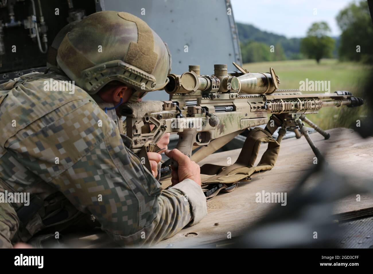 A Latvian soldier scans a field for targets in a downed aircraft during the 2021 European Best Sniper Team Competition at the Hohenfels Training Area, Germany, Aug. 10, 2021. The 2021 European Best Sniper Team Competition is a U.S. Army Europe and Africa-directed, 7th Army Training Command hosted contest of skill that includes 14 participating NATO allies and partner nations at 7th ATC's Hohenfels Training Area, August 8-14. The European Best Sniper Team Competition is designed to improve professionalism and enhance esprit de corps. (U.S. Army Photo by Cpl. Shawn Pierce) Stock Photo