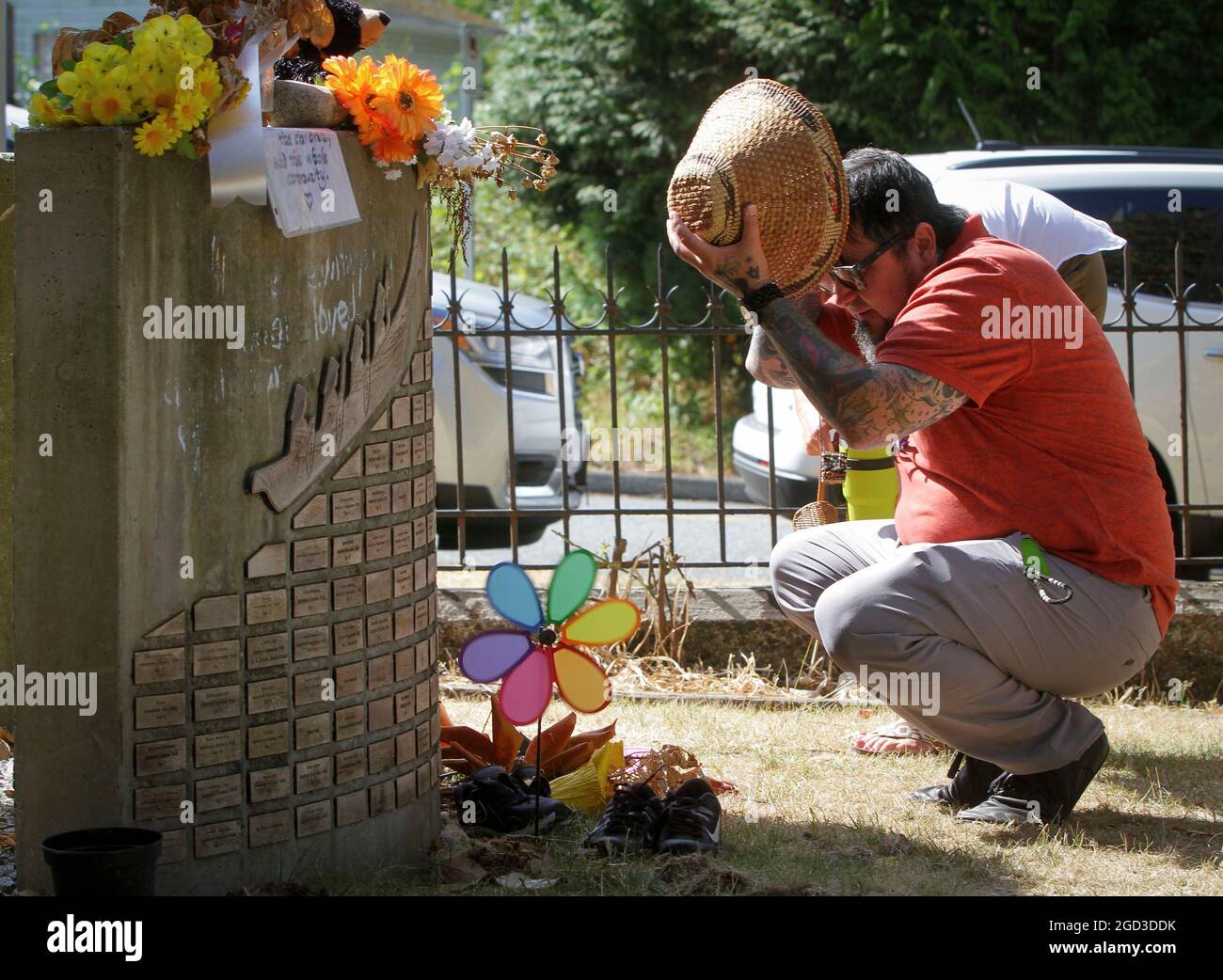 North Vancouver, Canada. 10th Aug, 2021. An indigenous man looks at names of the missing children that carved on a memorial at the site of the former St. Paul Indian Residential School in North Vancouver, British Columbia, Canada, on Aug. 10, 2021. Three British Columbia First Nations said they will work together to investigate the disappearance of indigenous children at the site of the former St. Paul's Indian Residential School in North Vancouver on Tuesday. Credit: Liang Sen/Xinhua/Alamy Live News Stock Photo
