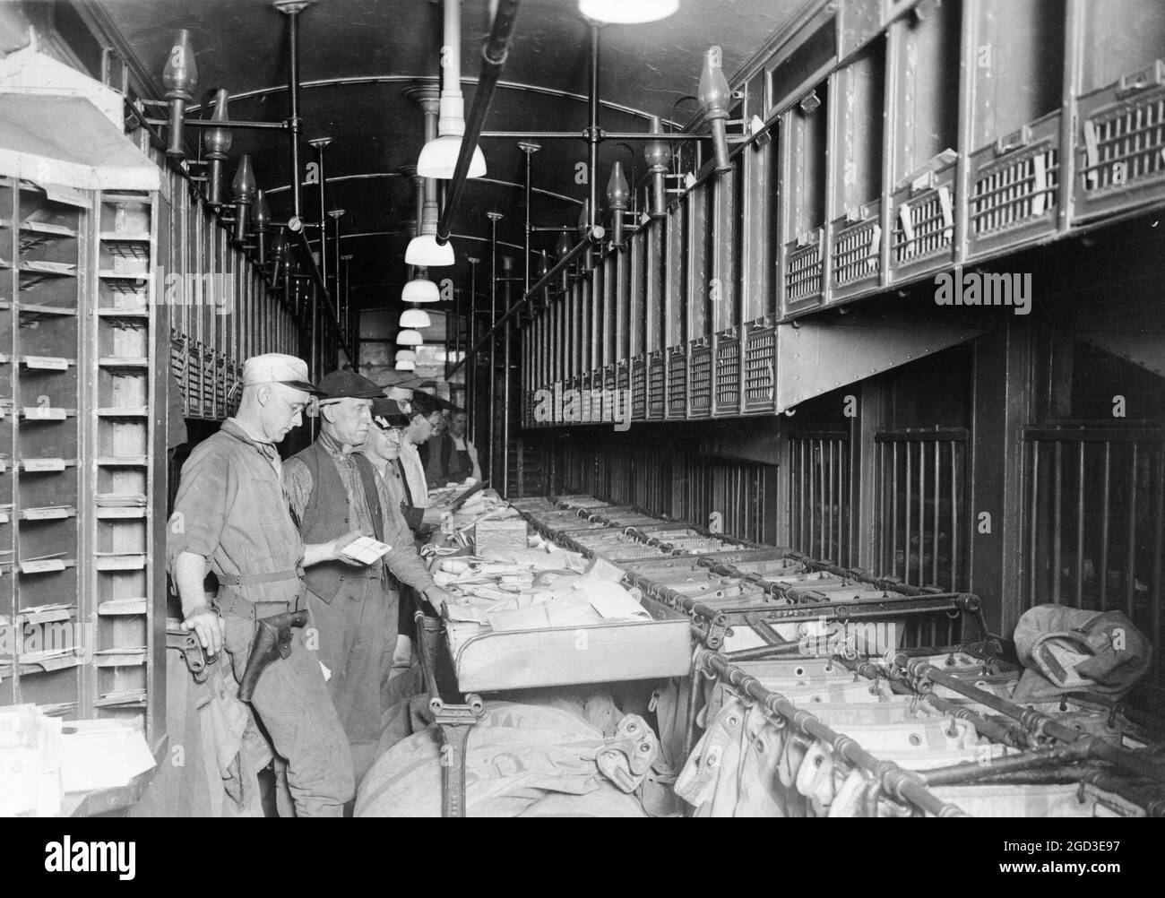 Men working in a railway mail train ca. 1909 Stock Photo
