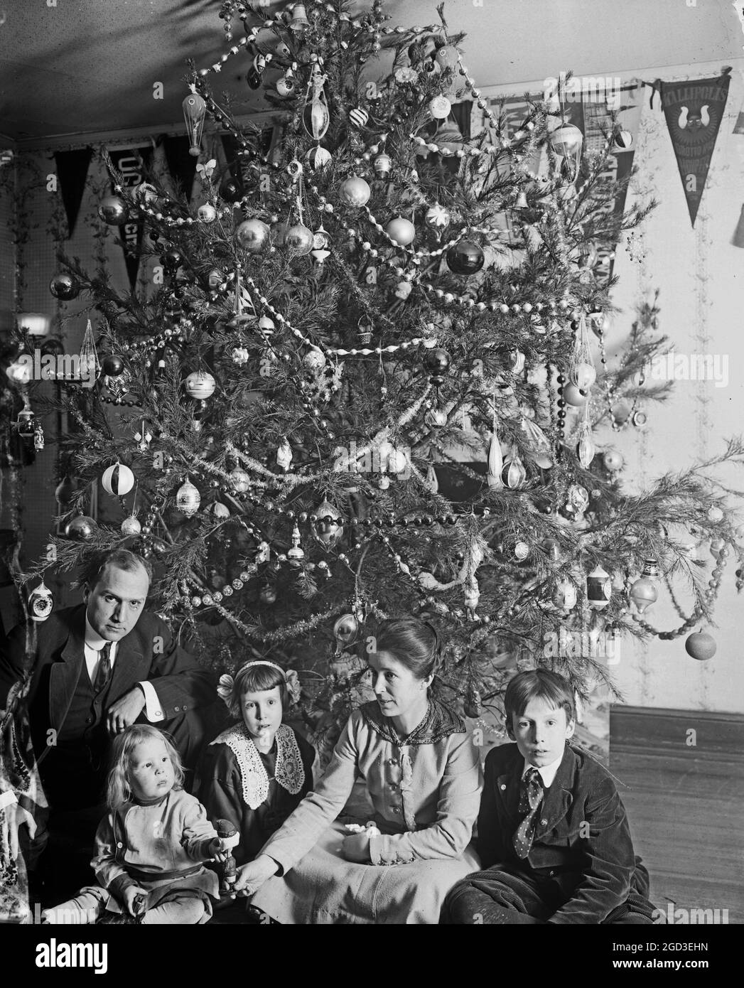 Historical family in front of christmas tree hires stock photography