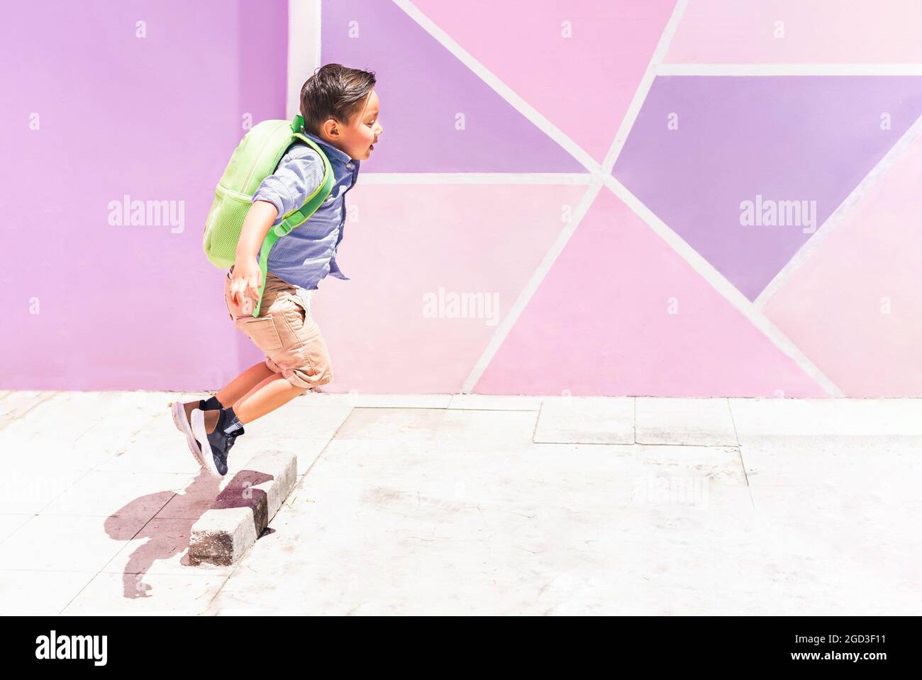 Little boy jumping with his backpack on the way to class. Back to ...