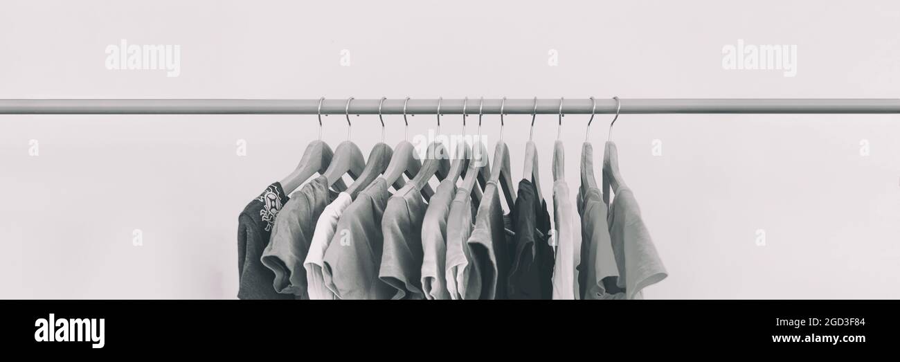 Clothing rack of women's closet organizing clothes for spring cleaning or fashion store outlet sale. Panoramic black and white style banner Stock Photo