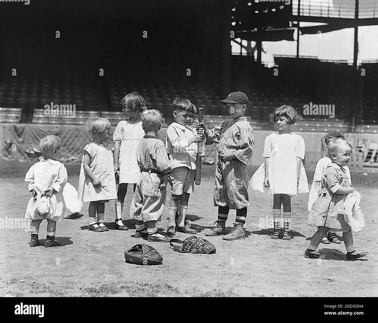 Spectators Pictured fanning the Flames of Baseball Passion, young boys and girls on the baseball field at a major league stadium between 1910 and 1930 Stock Photo