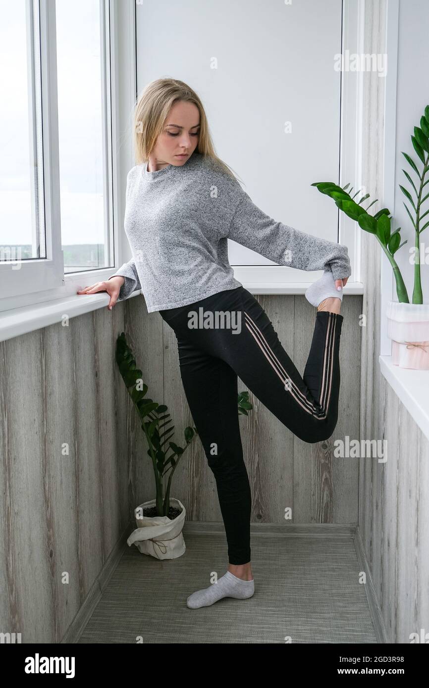 Young millennial blonde woman doing yoga exercise stretching
