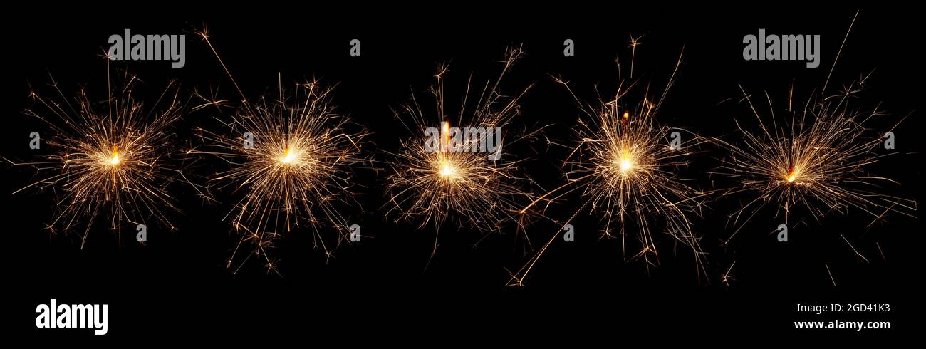 Wide panoramic design of Christmas sparkler lights isolated on black background. Set of Bengal and sparkler firework. Stock Photo