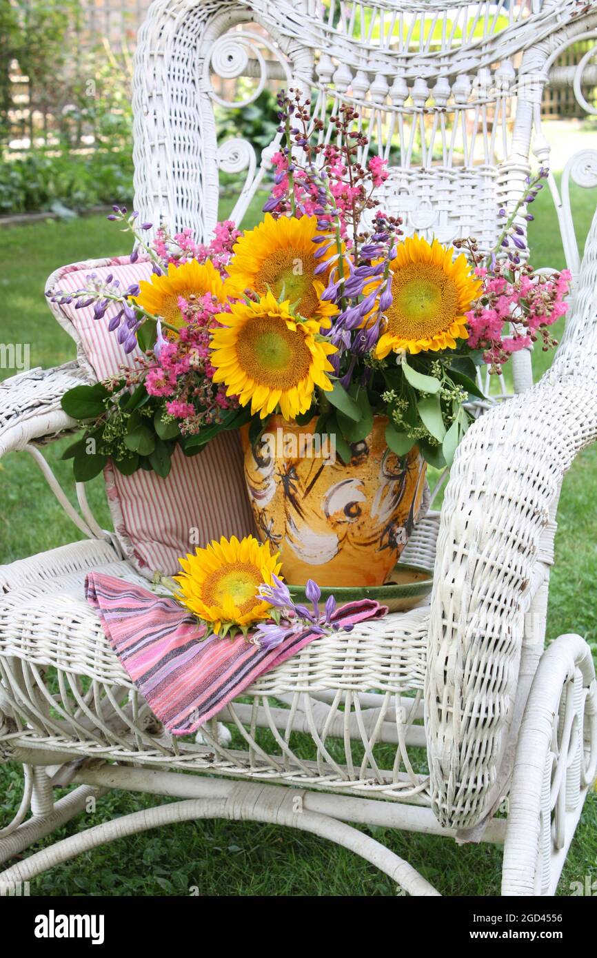 botany, sunflowers with hosta flowers in a vase on a fancy white wicker