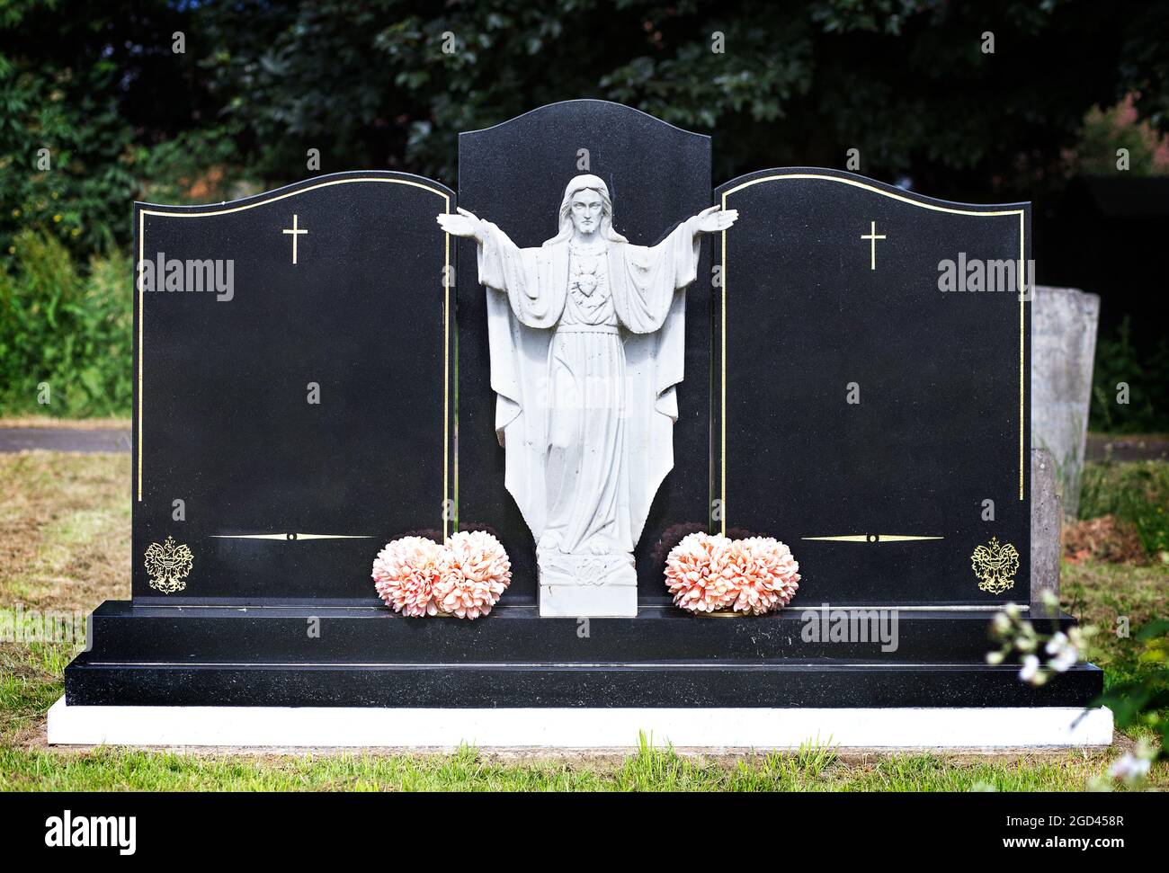 Blank elaborate gravestones with jesus figure in between and flowers at ...