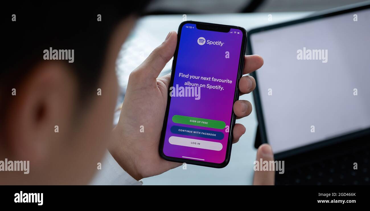 CHIANG MAI, THAILAND - APR 06, 2021: Person holding a brand new Apple iPhone XS with Spotify logo on the screen. Spotify is a popular commercial music Stock Photo