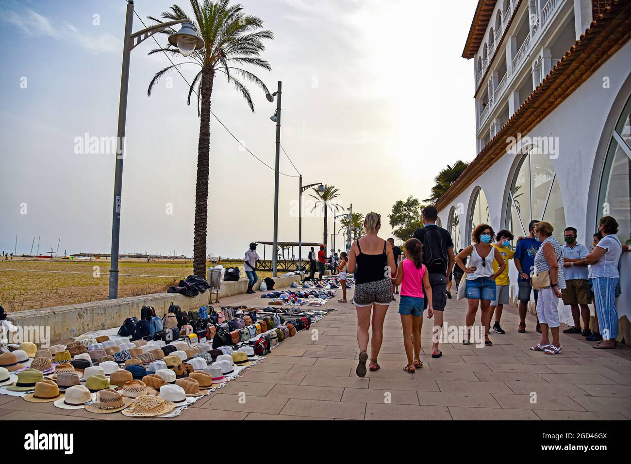 Vendrell, Spain. 05th Aug, 2021. People walk in front of the illegal  products sold by street vendors in Vendrell. Illegal street vendors known  as "manteros" or "Top Manta", mostly of Senegalese nationality,