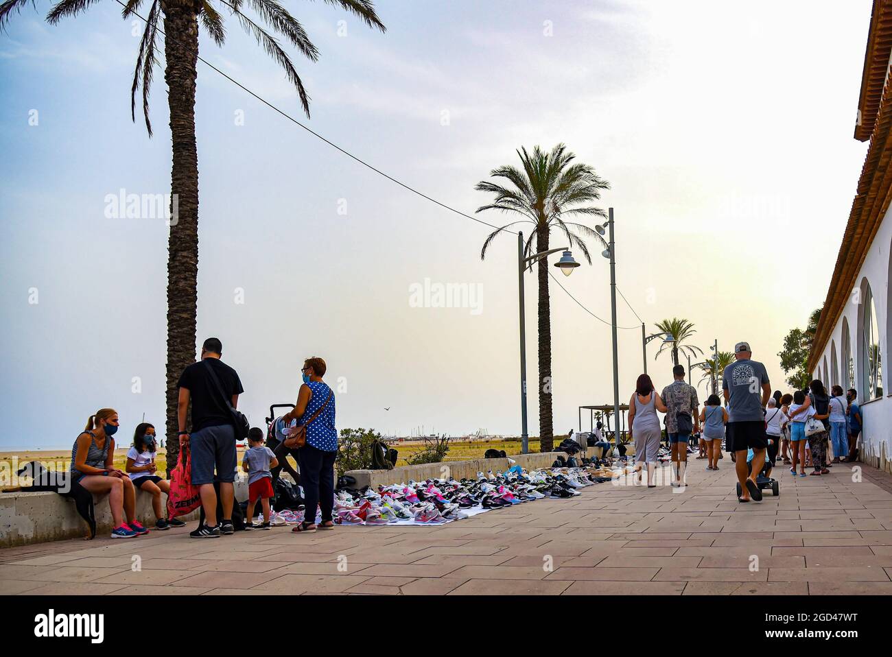 Vendrell, Tarragona, Spain. 5th Aug, 2021. People walk in front of the  illegal products sold by street vendors in Vendrell.Illegal street vendors  known as ''manteros'' or ''Top Manta'', mostly of Senegalese nationality,
