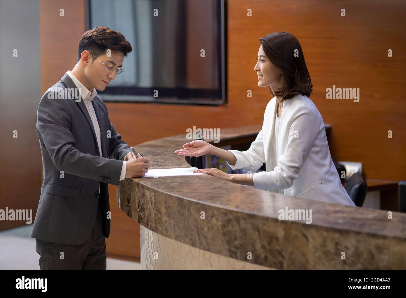 Businessman checking in at front desk Stock Photo Alamy