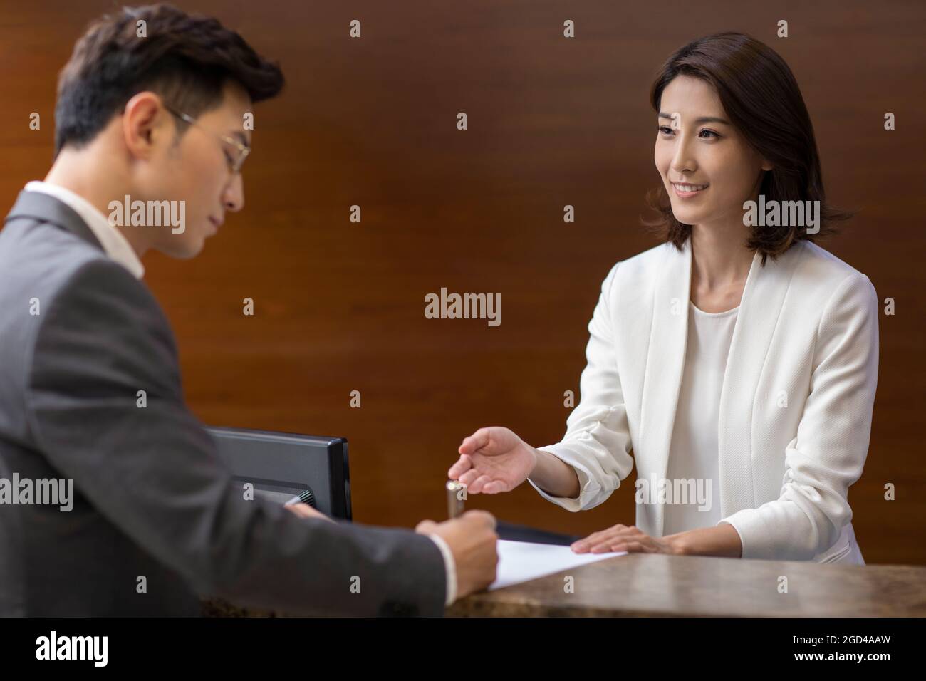 Businessman checking in at front desk Stock Photo