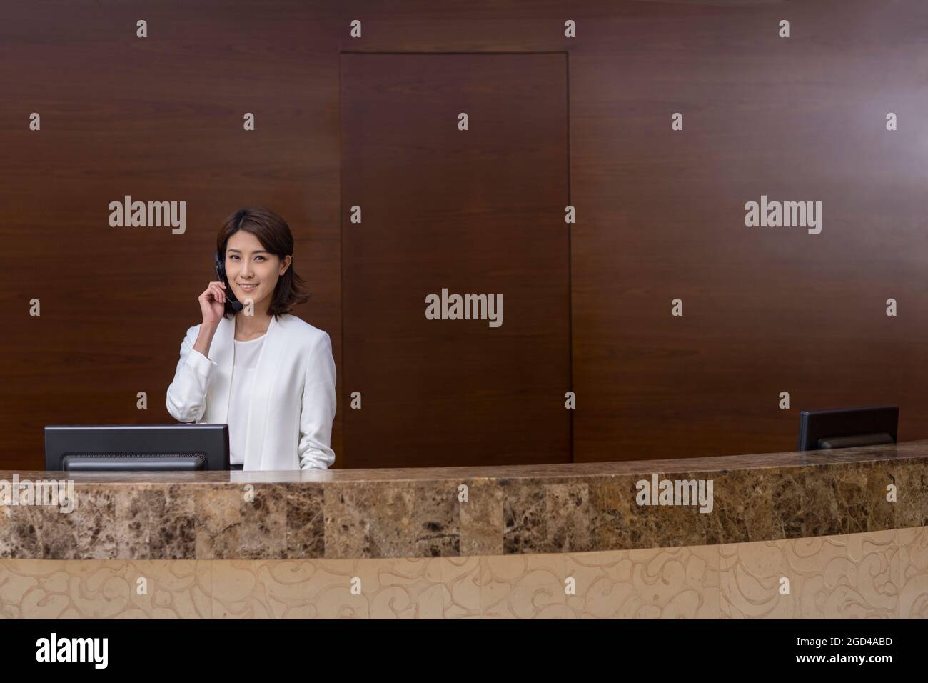 Hotel receptionist working with headset Stock Photo