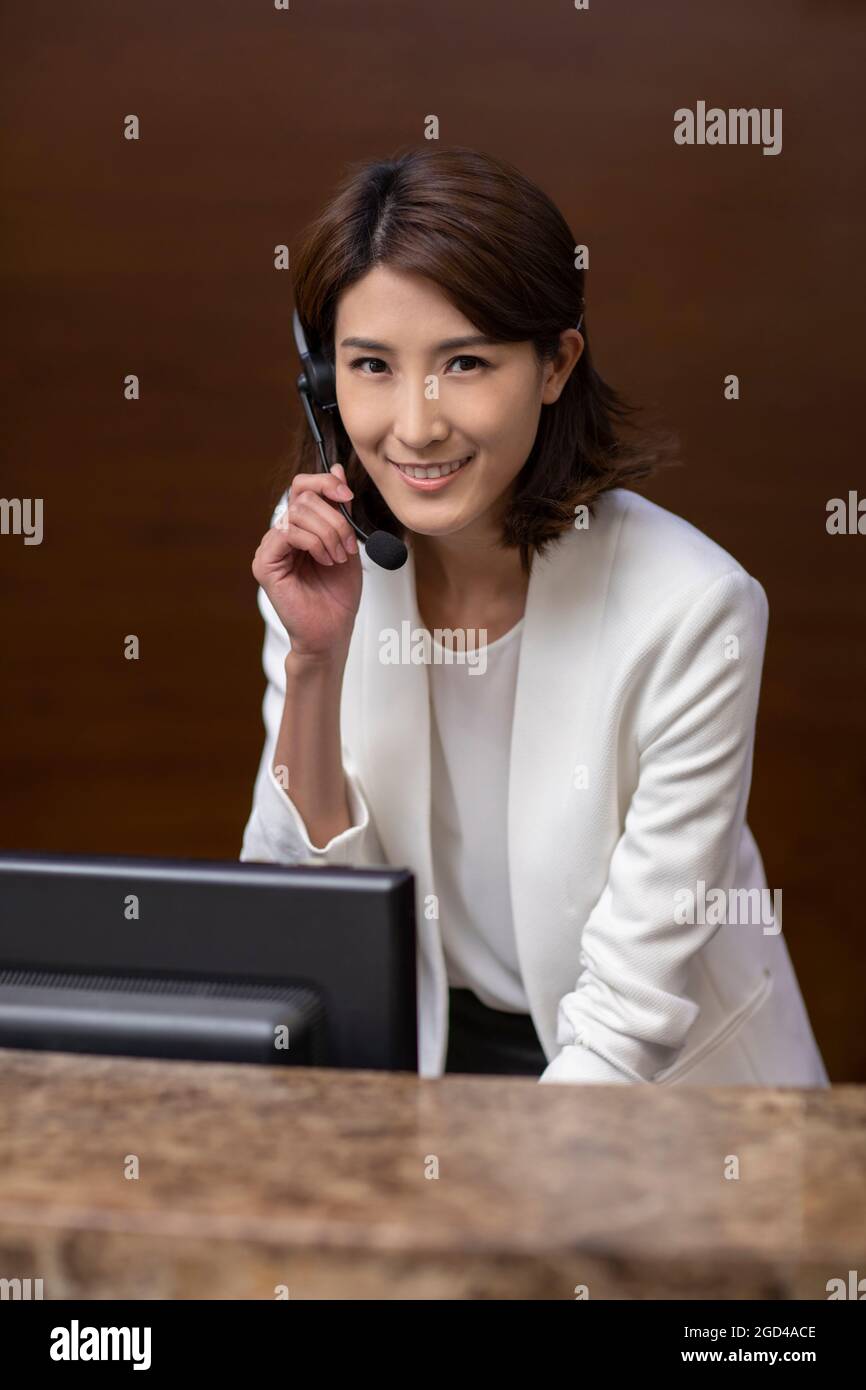 Hotel receptionist working with headset Stock Photo