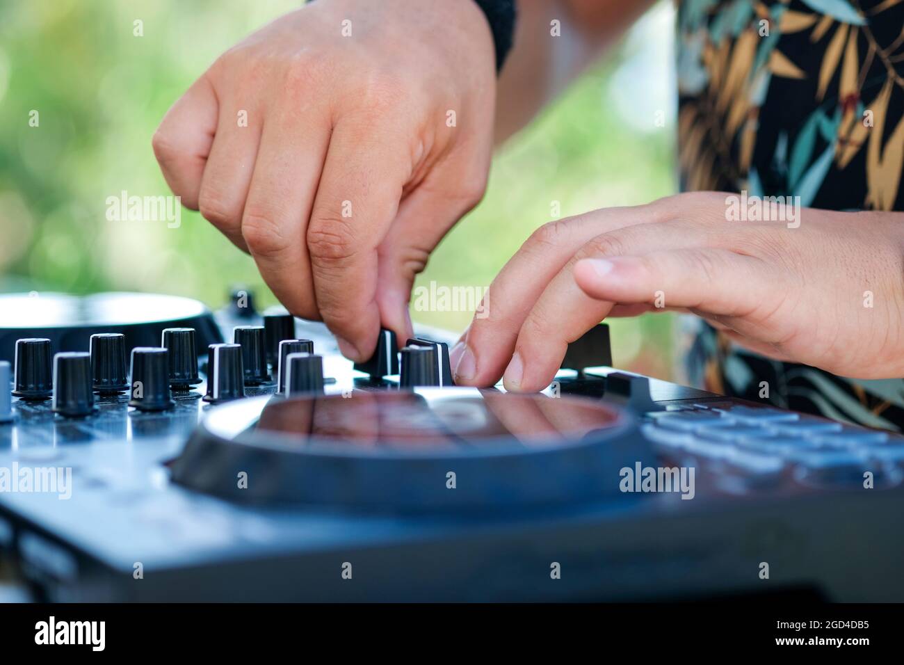 DJ Hands creating and regulating music on dj console mixer in beach club stage.  Stock Photo