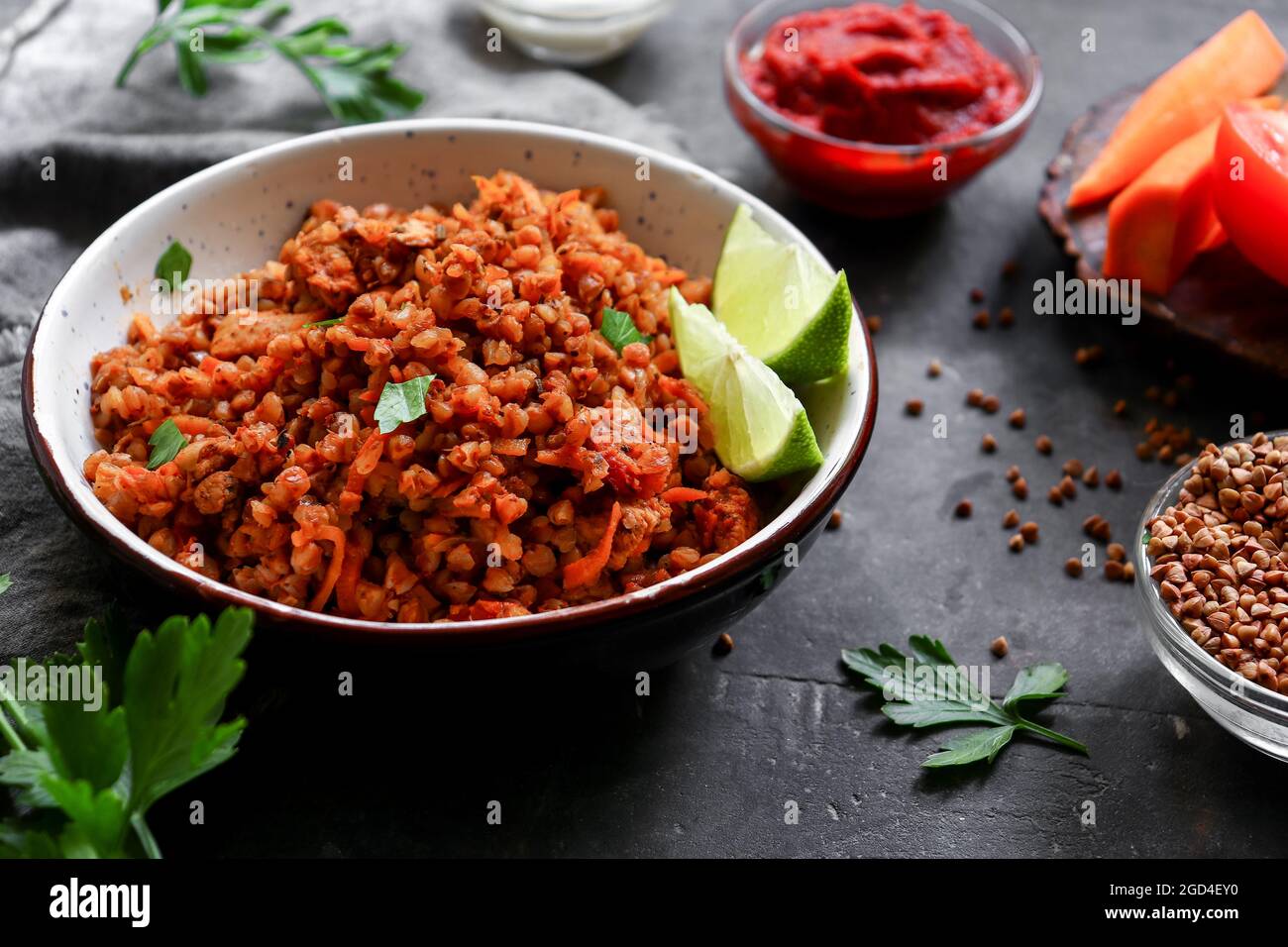 Healthy food concept. Buckwheat porridge with tomato sauce. Dark background. Copy space. Diet lunch. Ingredients. Stock Photo