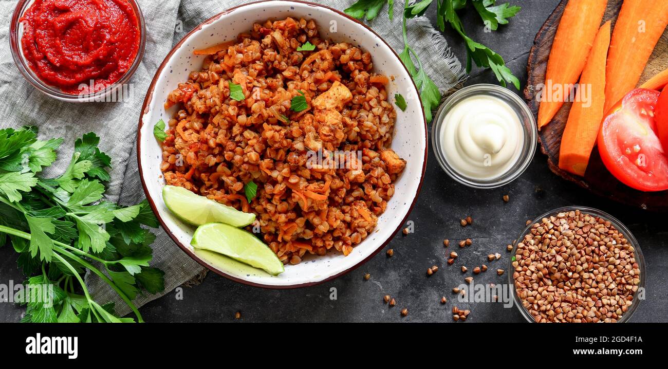 Healthy food concept. Buckwheat porridge with tomato sauce. Top view. Dark background. Copy space. Diet lunch. Ingredients. Food banner. Stock Photo