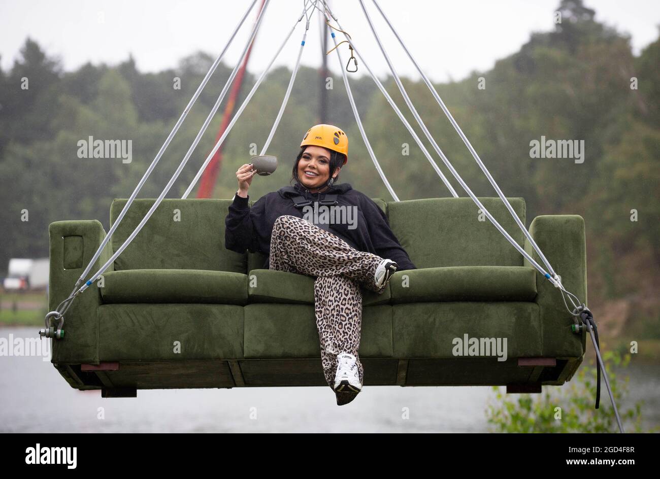 EDITORIAL USE ONLY Scarlett Moffatt, sitting on her sofa, zip lines for 200-metres, 25 metres above the ground at Buckland Park in Surrey, as research highlights the public's post-lockdown 'unbreakable bond' with their couches, revealing that almost 1 in 6 people surveyed admitted to cancelling on friends for a night in, despite Coronavirus restrictions being eased. Issue date: Wednesday August 11, 2021. Stock Photo